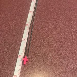 Dainty silver toned chain with a an adorable pink cross